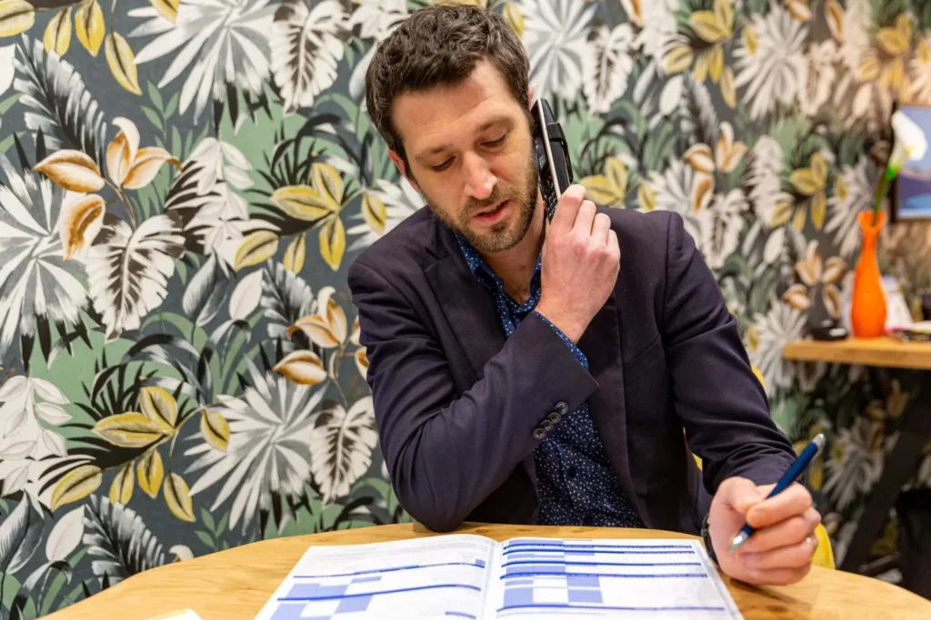 Conseiller funéraire au téléphone remplissant un dossier d'organisation d'obsèques.