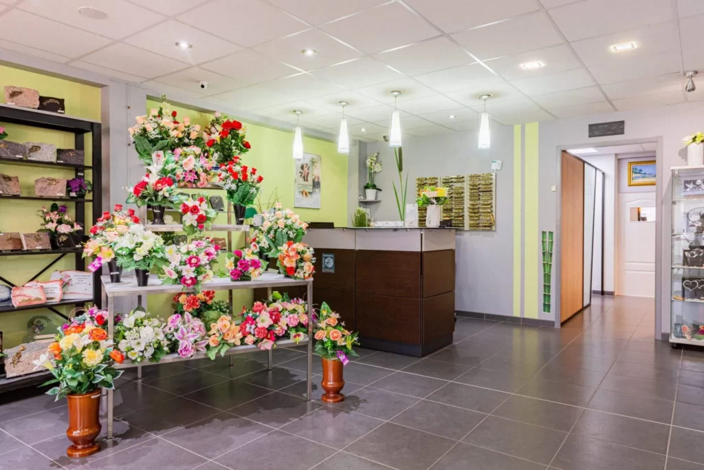 Hall d'accueil d'une agence funéraire proposant des fleurs et plaques mortuaires.