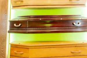Exposition de différents modèles de cercueils en bois en agence funéraire.