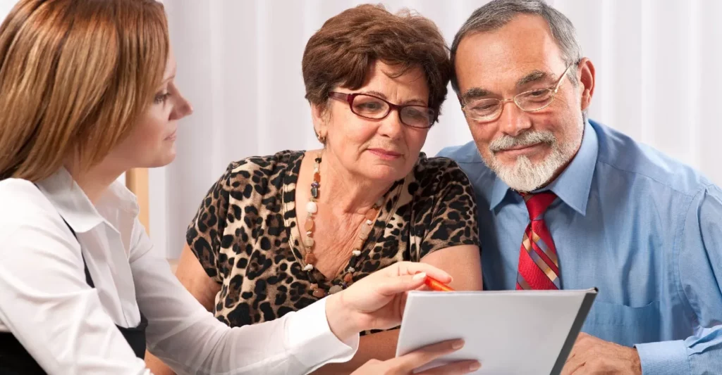 Couple senior signant un contrat de prévoyance obsèques avec une conseillère.
