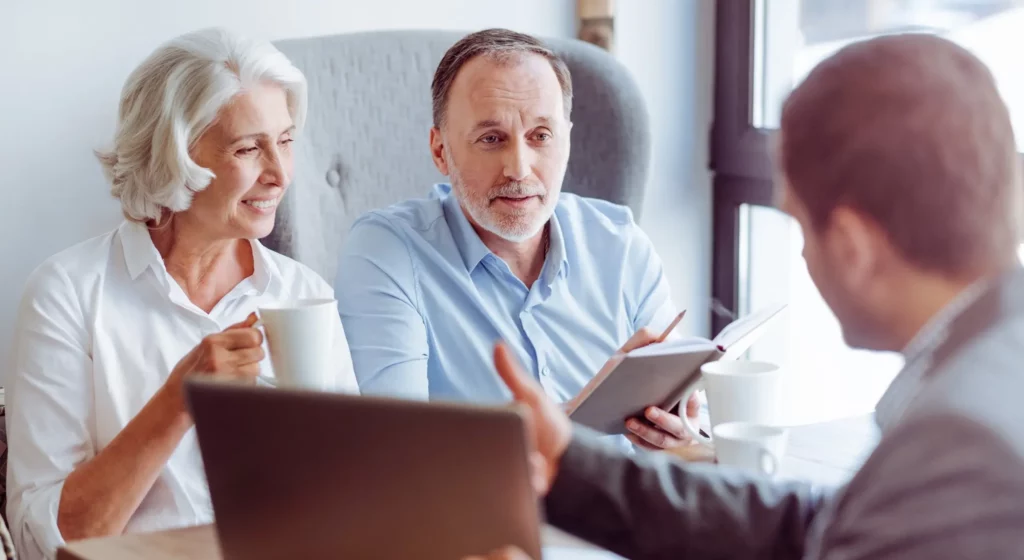 Couple senior en entretien avec un conseiller pour un contrat de prévoyance obsèques.